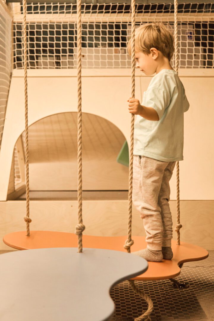 chłopiec bawi się w drewnianym małpim gaju