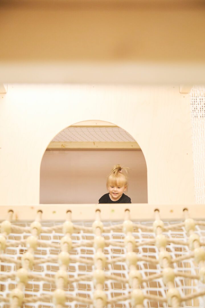 dziewczynka bawi się w drewnianym małpim gaju