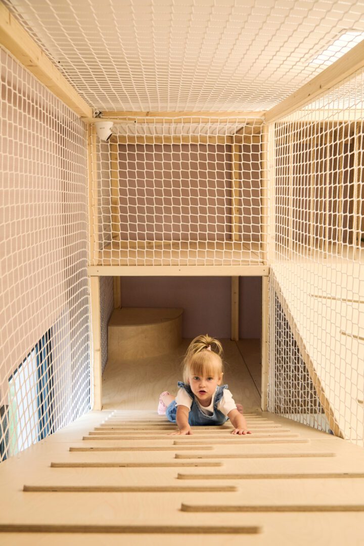 dziewczynka wspina się po drewnianym podeście montessori